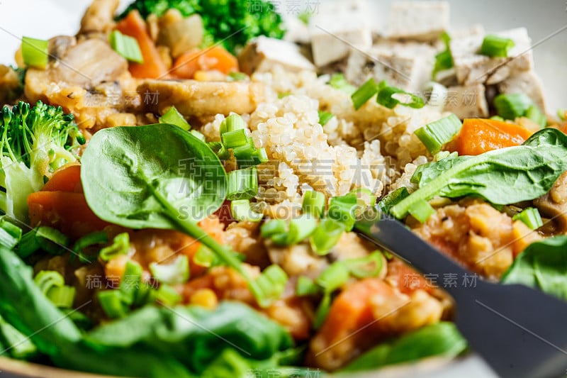 扁豆素炖蘑菇，藜麦，菠菜和西兰花在一个碗。健康素食的概念。