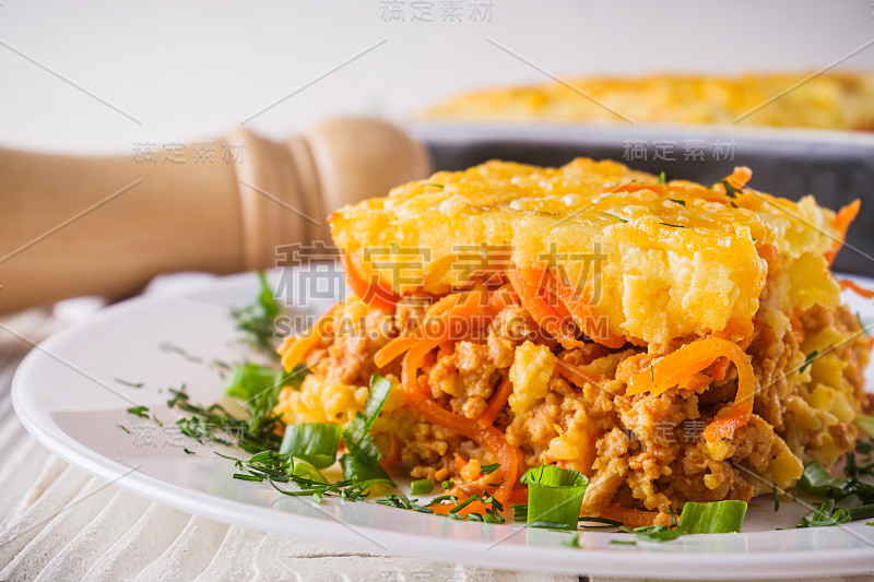 美味的土豆砂锅，肉和奶酪在白色的木制背景