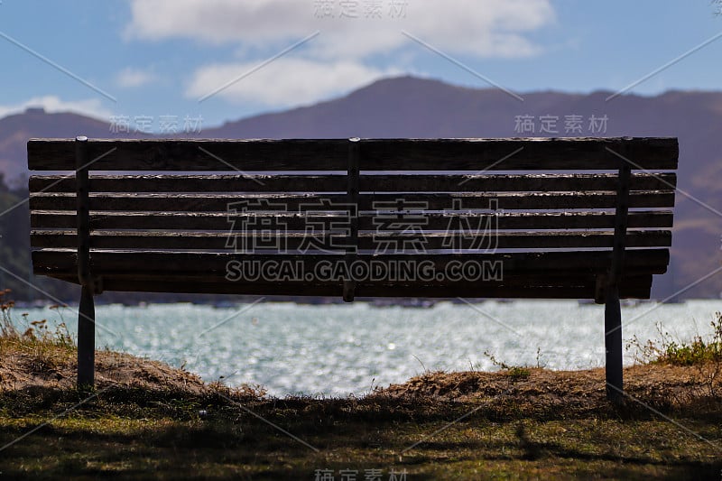 一张空长凳的特写，背景是群山