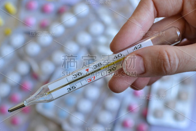 玻璃水银温度计在药片的背景上。