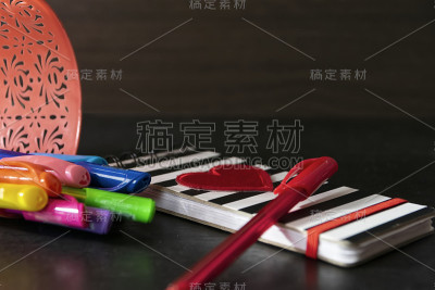 一组彩色笔和封面上有爱心的笔记本