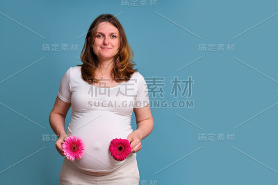 孕妇用两朵红花，蓝色背景的双胞胎受孕概念
