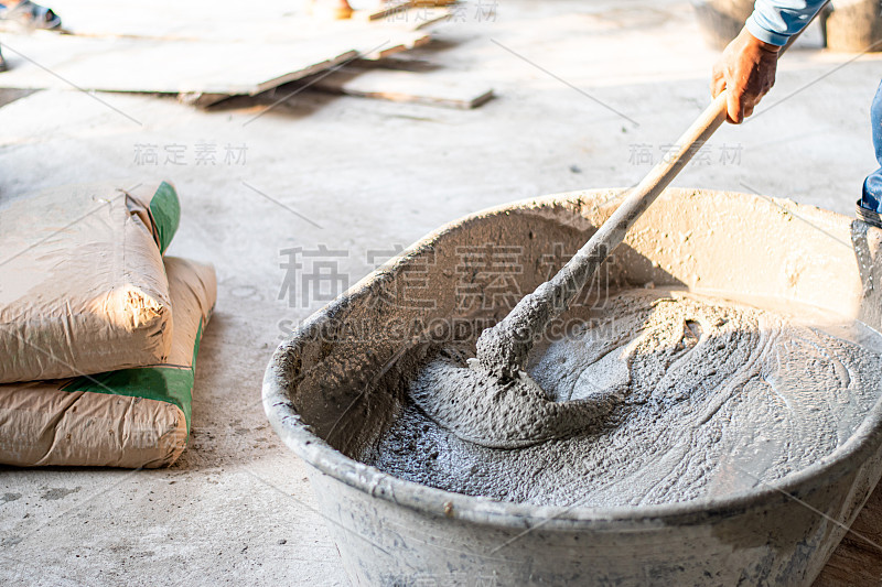 建筑工人正在工地上搅拌水泥。