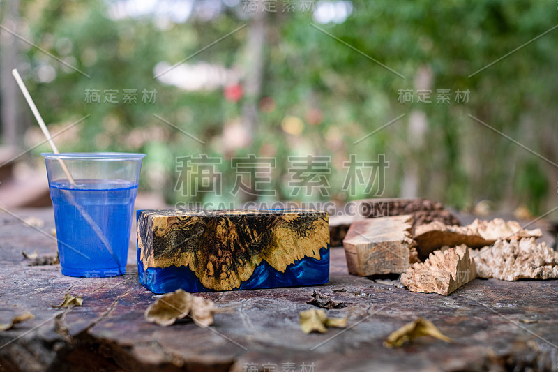 在旧桌子艺术背景上浇铸绿色环氧树脂树节木立方体，自然阿夫泽里亚木