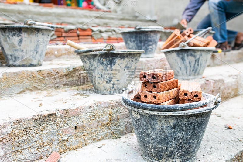 工人劳动，搅拌机操作员在建筑工地用混凝土、水泥和砖建造楼梯。