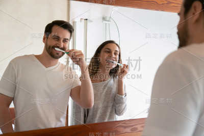 微笑的白人年轻夫妇一起刷牙