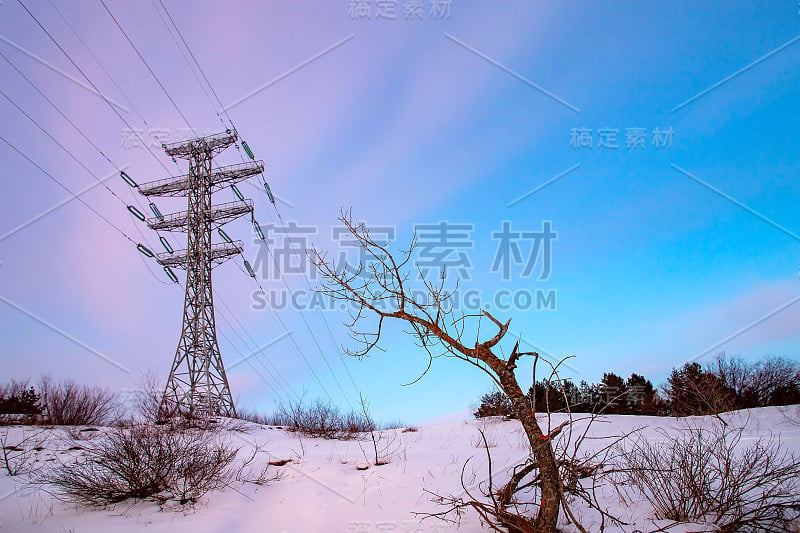 日落时蓝天背景上的高压电缆塔和输电线路。