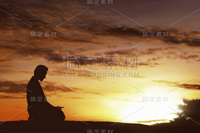 亚洲穆斯林男子在山顶祈祷的剪影