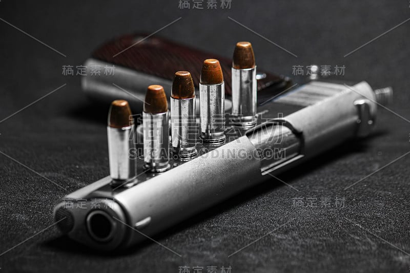 自动白色手枪不锈钢手枪武器模型m1911与真正的子弹弹药头在黑色的背景