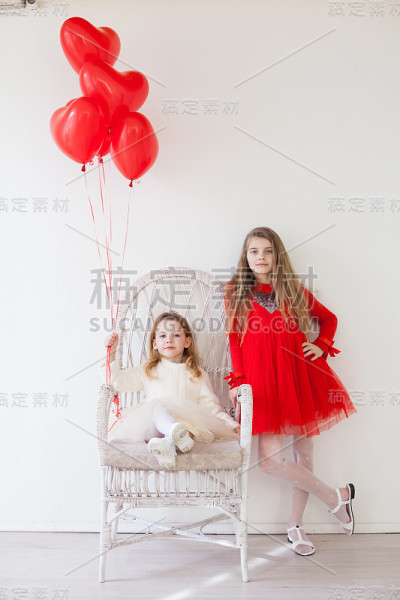 孩子们是漂亮的女孩拿着红色的气球