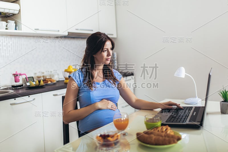 有肚子的孕妇用笔记本电脑做自由职业者