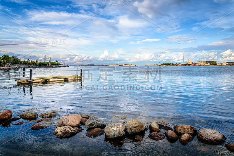 风景码头在哥本哈根港日落与岩石的前景