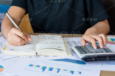 女人用计算器和书写手写笔记和计算