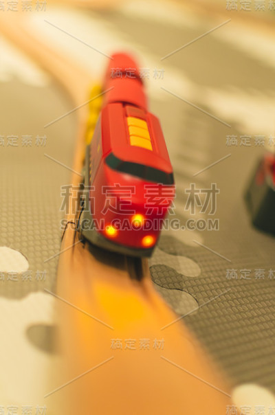 红色的玩具火车，木制的栏杆