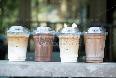 户外咖啡店的桌子上放着四杯冰咖啡饮料