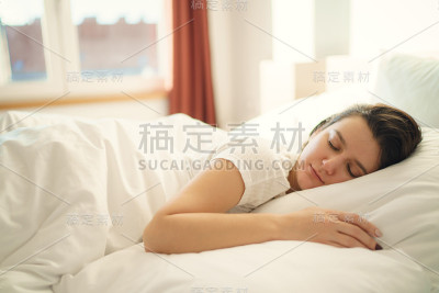 一个年轻美丽的女人独自睡在卧室的床上