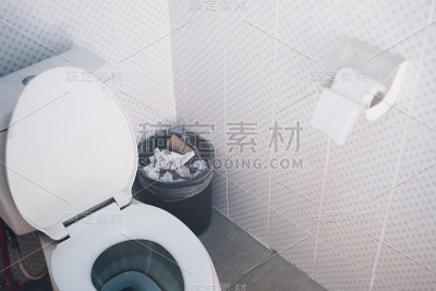 冲洗马桶和纸巾盒与污迹在马桶。