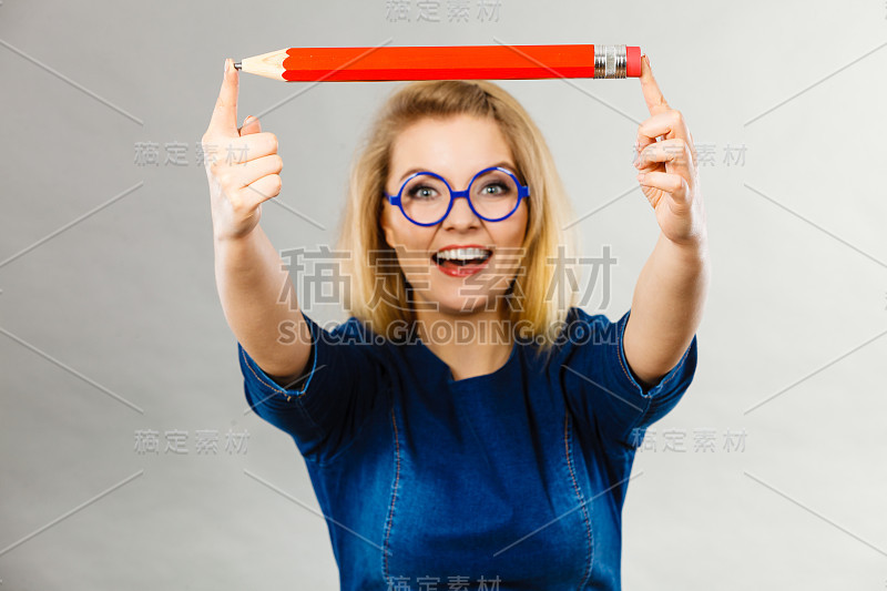 微笑的女人手里拿着一支大铅笔