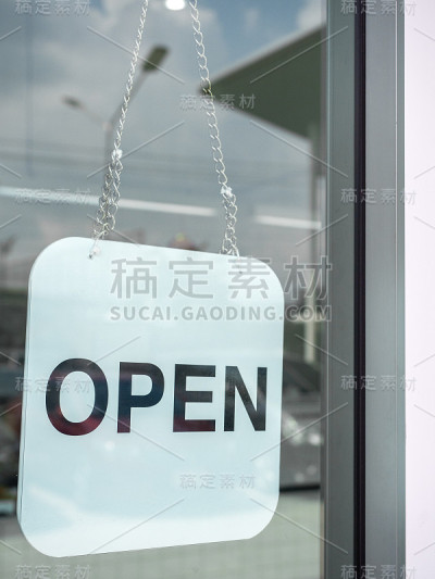 咖啡店的玻璃门上挂着白色的开放标志。