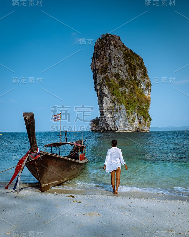 泰国Koh Poda Krab，一名戴着帽子的妇女在一个晴朗的日子与蓝天的Koh Poda岛的海滩上