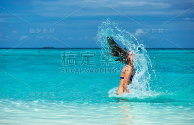女人用头发往海里泼水