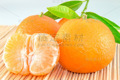 用木棒切成片和叶子的橘子