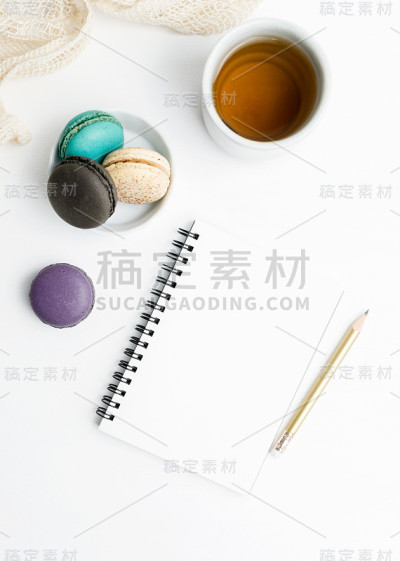 俯视图平铺空白笔记本模型，有马卡龙和茶杯。艺术,写作的概念
