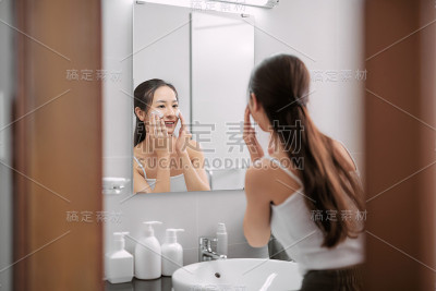 在浴室里用泡沫洁面的漂亮女人