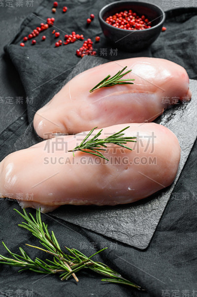 有机农场的肉。切菜板上的生鸡胸肉。新鲜的角。黑色背景