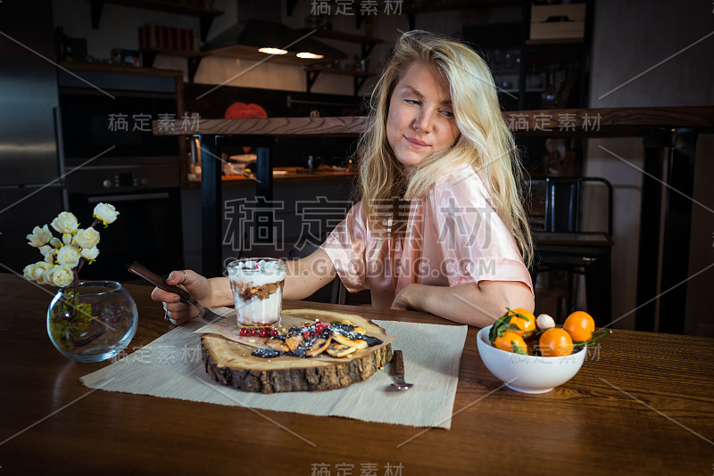 年轻女子吃新鲜煎饼配甜点