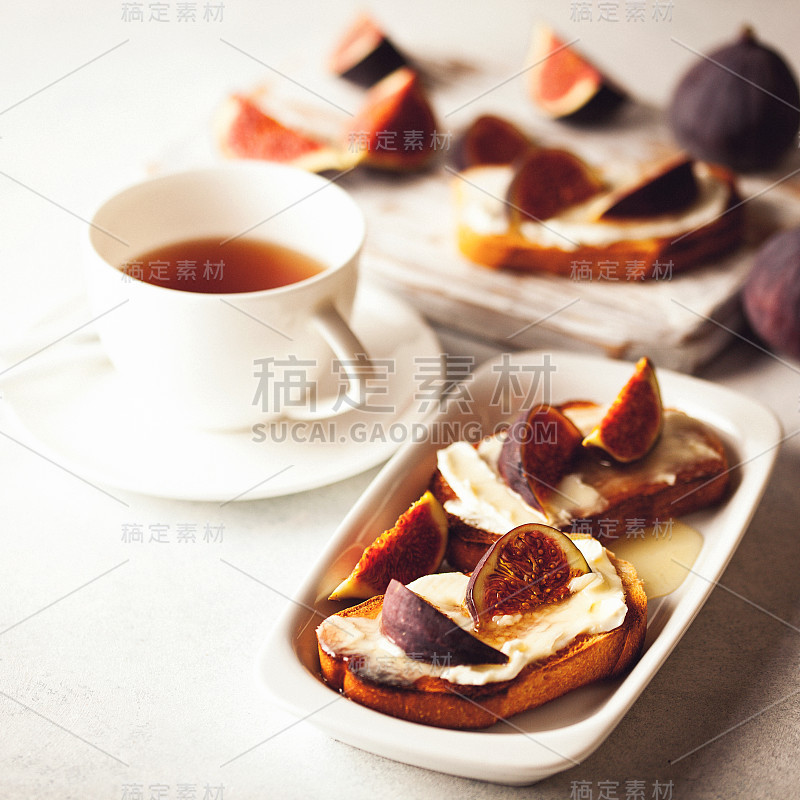 意式烤面包配无花果，乳清干酪(奶油奶酪)，蜂蜜。健康食品的概念。前视图。