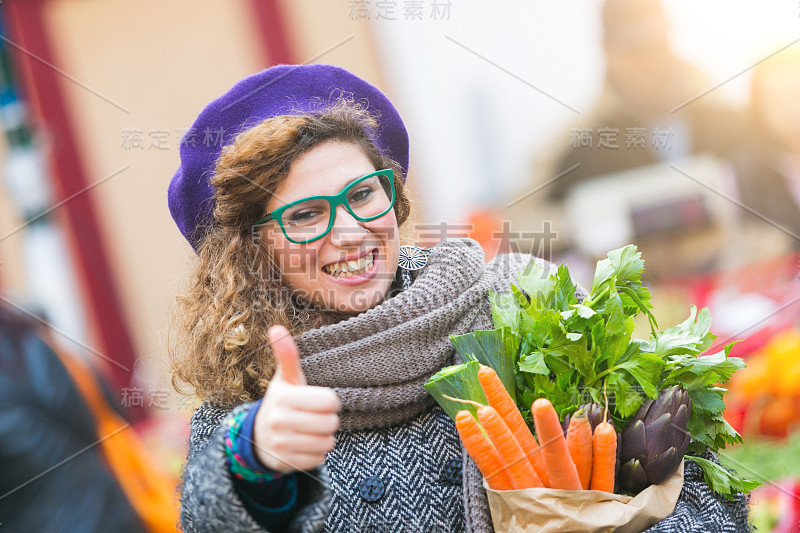 年轻女子在当地市场买菜