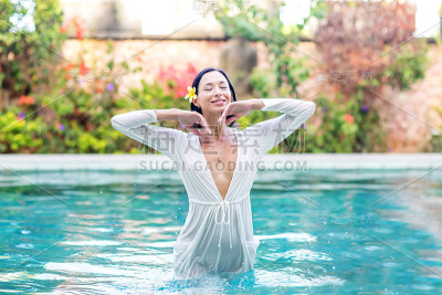 日落时泳池里的美女