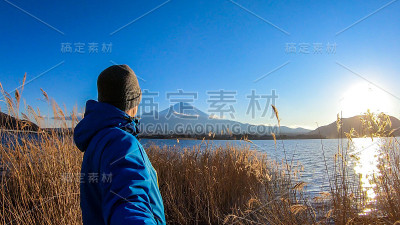 日本——一名男子站在川口湖边，眺望富士山