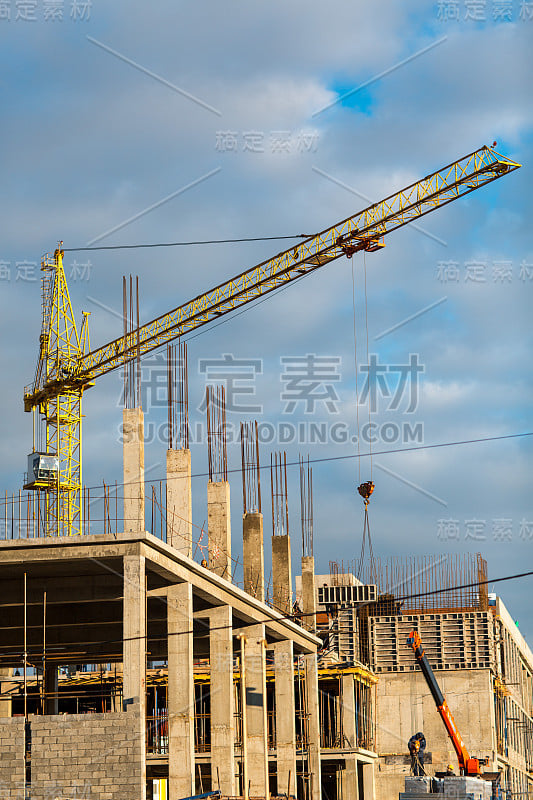 用起重机概念建造房屋。蓝色的天空背景。