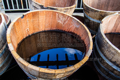 装满水的旧半桶水反映了周围的环境。