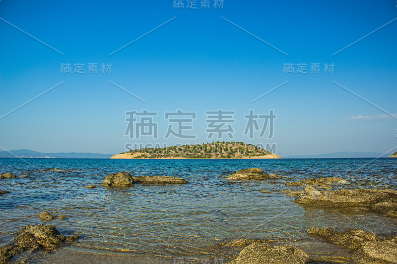 地中海岛屿景观岩石海岸线前景和地平线板与蓝天背景空拷贝空间为您的文字，在暑假时间放松的美丽目的地