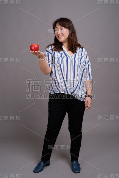 工作室拍摄的成熟美丽的亚洲女商人在灰色的背景