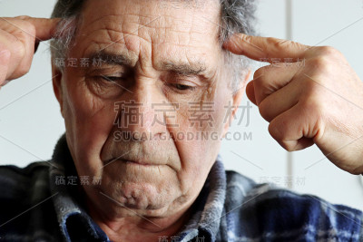 一位老人用她的手按摩太阳穴