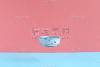 空的蓝色碗漂浮在蓝色和粉红色的背景上