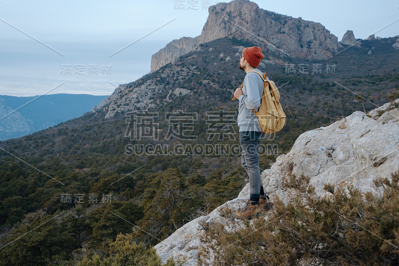 男人背包徒步旅行和红帽子在山区