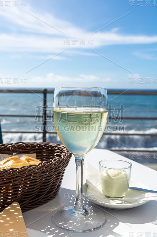 夏日海上度假，在阳光明媚的户外露台上喝着白葡萄酒