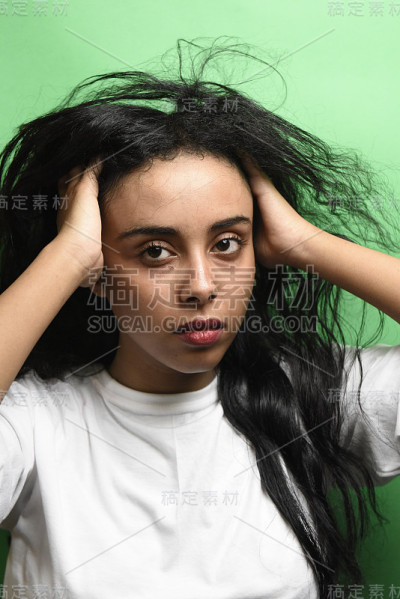 有着一头黑发的中东年轻女子。室内照片的奇妙女性模特在绿色的背景。