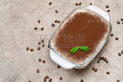传统的意大利提拉米苏甜点在玻璃烤盘在混凝土背景