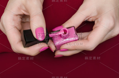 美丽的女性手与温暖的粉红色指甲设计