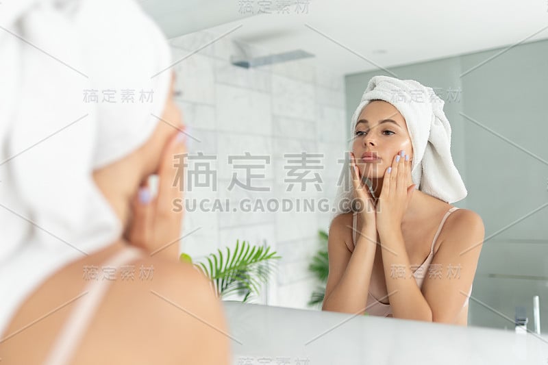 年轻美丽的女人使用皮肤面霜乳液