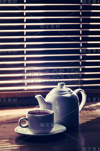 旧木桌上放着茶杯和茶壶
