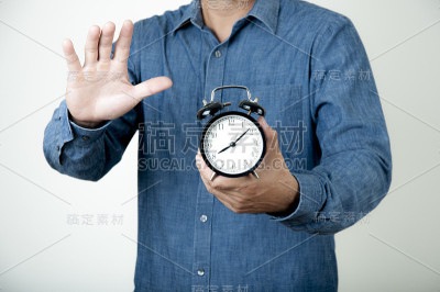 时间的概念。一个人手里拿着一个闹钟。早上上班时间