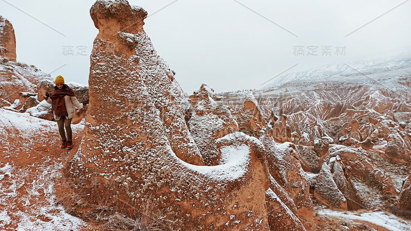 在卡帕多西亚德夫特山谷，一个女人独自面对雪景。