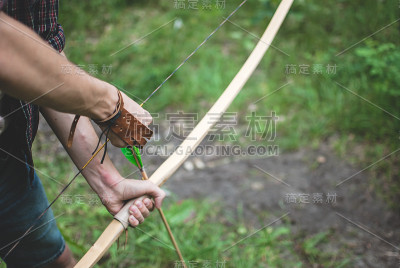 弓箭手用手搭箭鞠躬。传统射箭